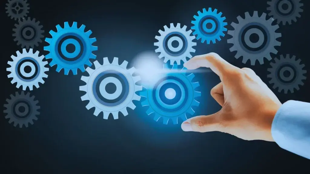 A hand interacts with glowing blue gears in a digital interface, depicting concepts of connectivity and technological innovation.
