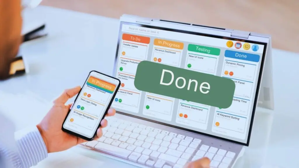 Close-up of a smartphone and laptop displaying task management applications with a 'Done' checkbox, illustrating digital project delivery and completion tracking