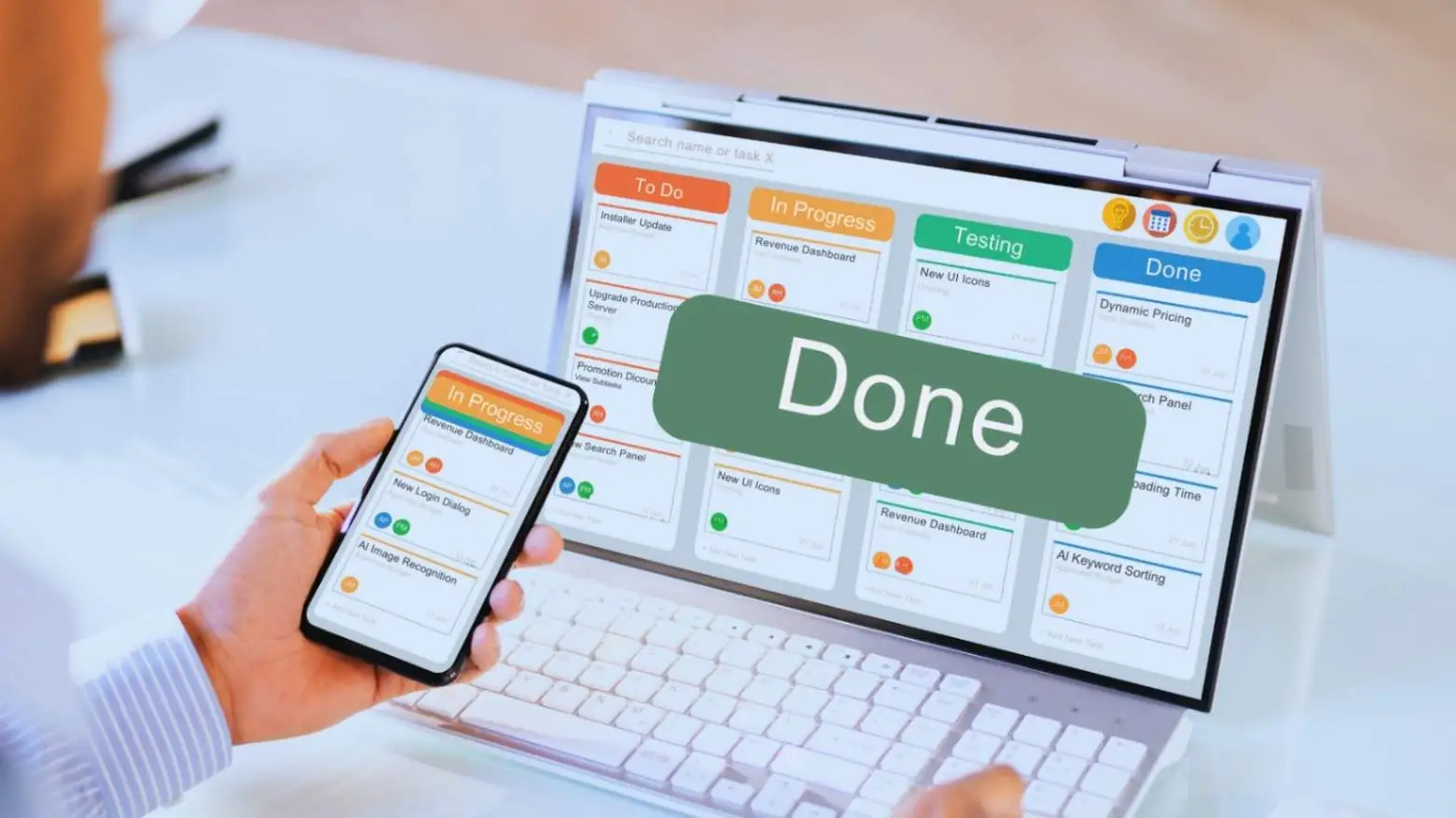 Close-up of a smartphone and laptop displaying task management applications with a 'Done' checkbox, illustrating digital project delivery and completion tracking