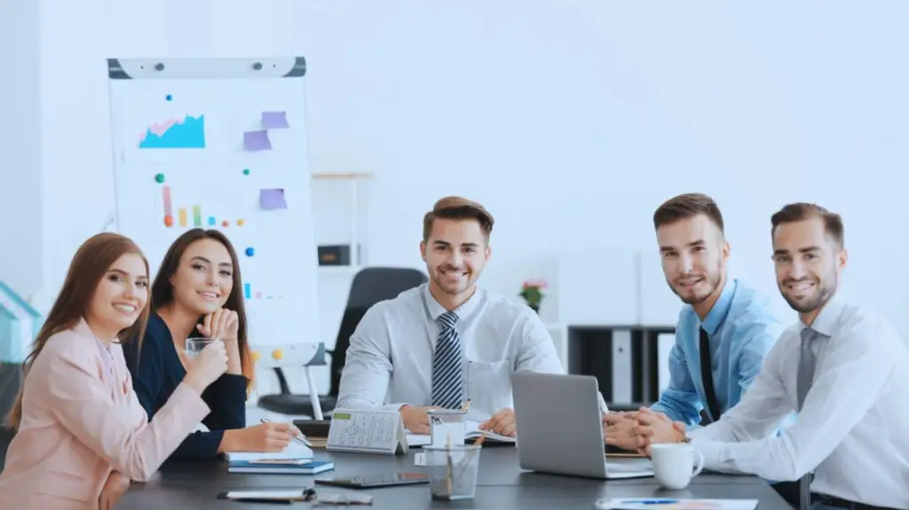 Young, diverse business team discussing charts and data in a modern office, highlighting teamwork, analytics, and collaborative planning.