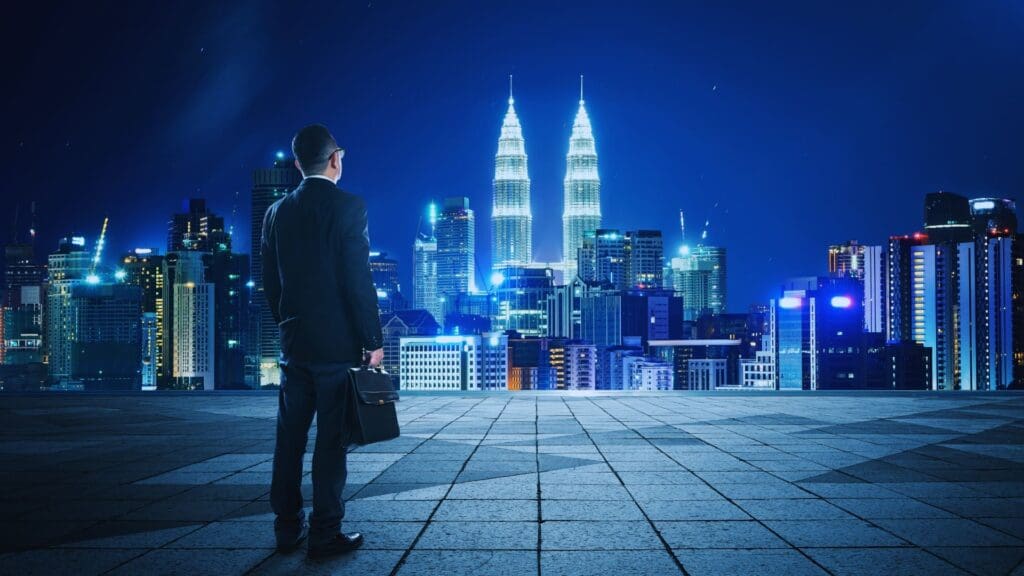 A businessman standing on a city rooftop at night, contemplating the skyline, symbolizing long-term goal setting and aspirations.
