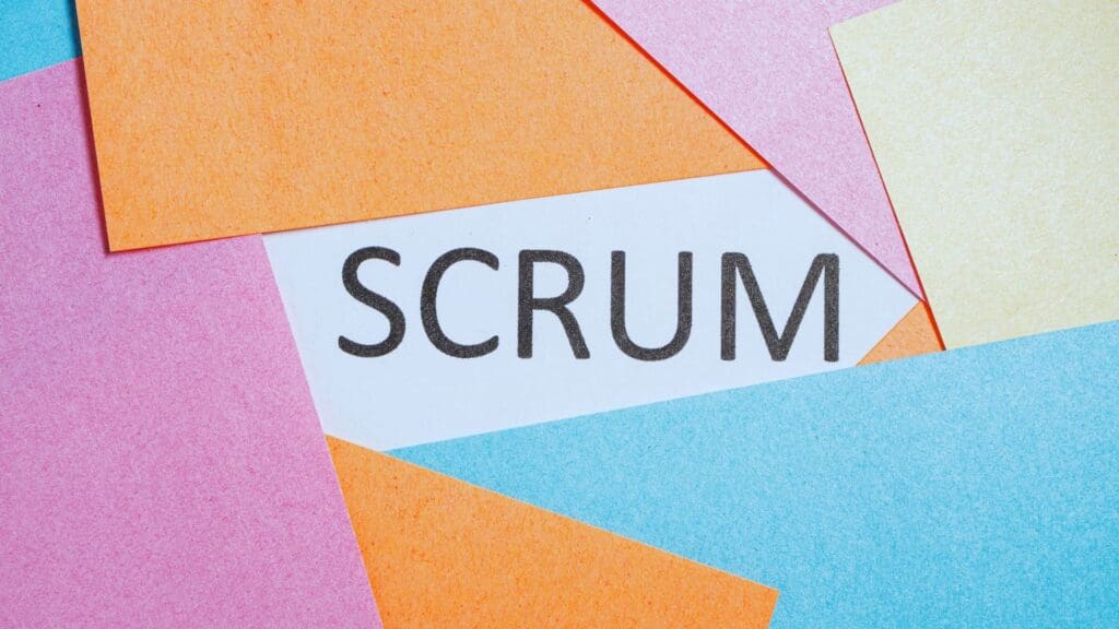 The word 'Scrum' surrounded by colorful sticky notes, representing the daily scrum process