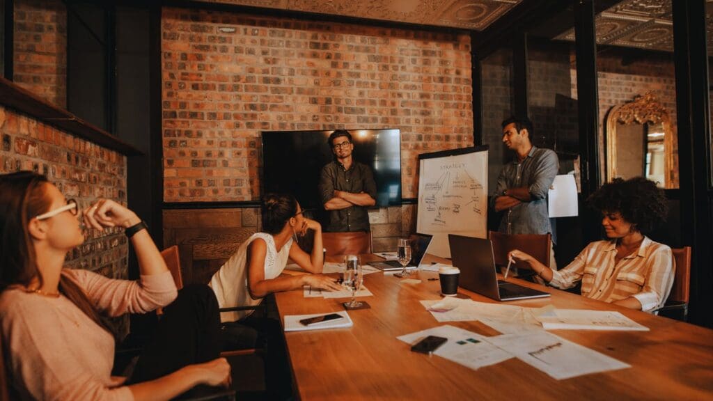 Diverse team engaged in a strategy meeting with a whiteboard presentation, focusing on Sprint planning for effective project management.