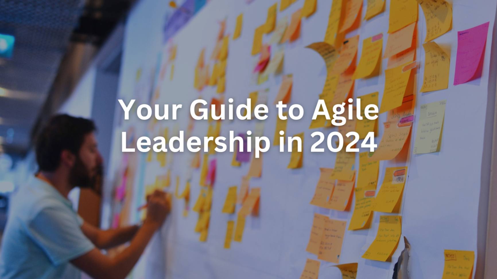 A man writing on a whiteboard filled with colorful sticky notes. This cover image emphasizes the evolving strategies in Agile leadership for 2024.