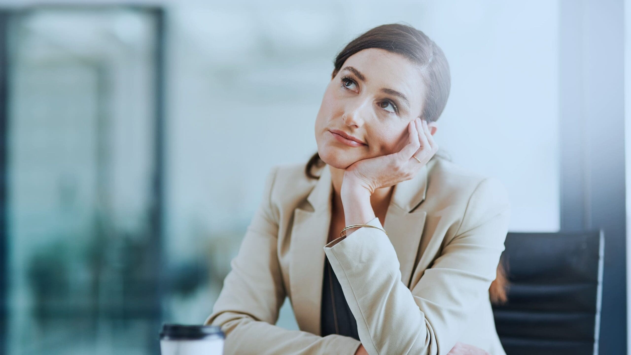 a woman sitting at a table with her hand on her chin