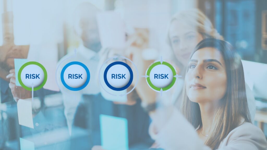 A group of business professionals stand behind a transparent screen, focusing on circular icons labeled “RISK,” as a woman in the foreground interacts with the screen, quantifying risk through data-driven analysis.
