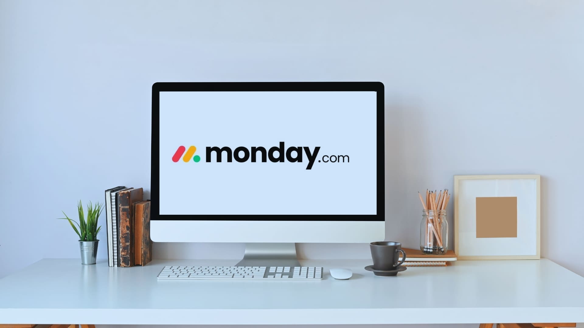 Workspace featuring a computer screen displaying the Monday.com logo, symbolizing its use as a CRM system.