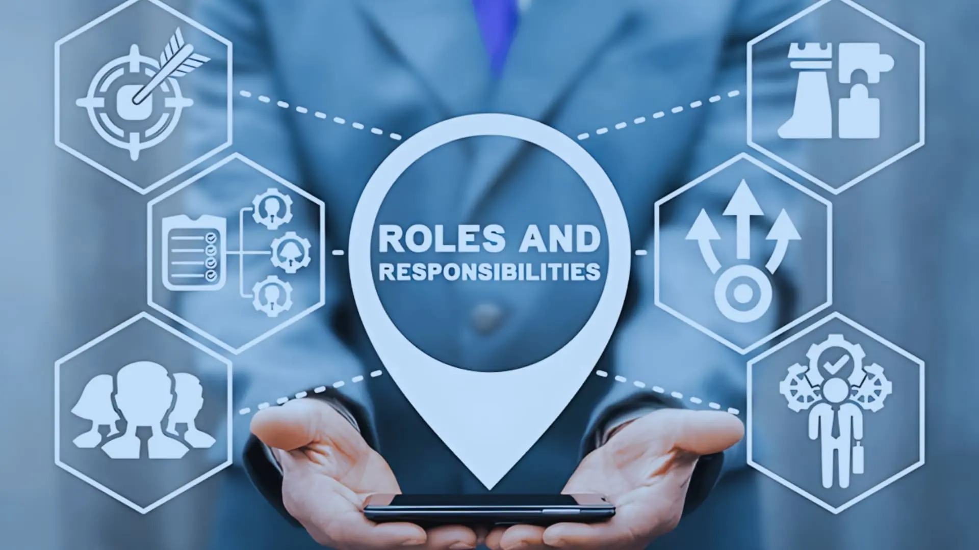 A person in a suit holds a smartphone with digital graphics above it, showing "Roles and Responsibilities" surrounded by icons representing Agile Coaching, teamwork, leadership, tasks, growth, and strategy.
