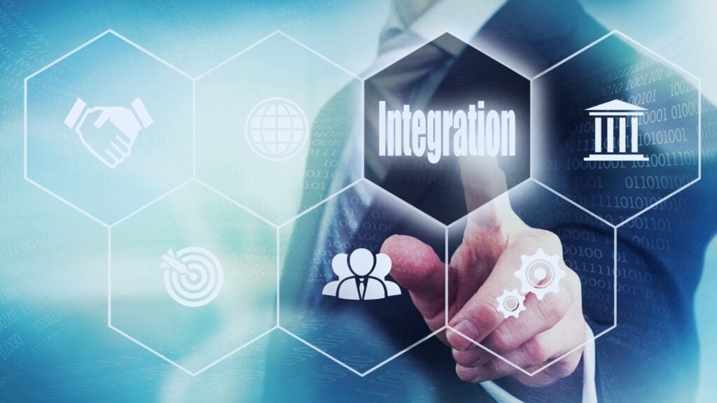 A person in a suit points at a transparent screen displaying "Integration," surrounded by hexagons with business icons like a globe, handshake, gears, and a bank—highlighting seamless TeamGantt Integrations for efficient project management.