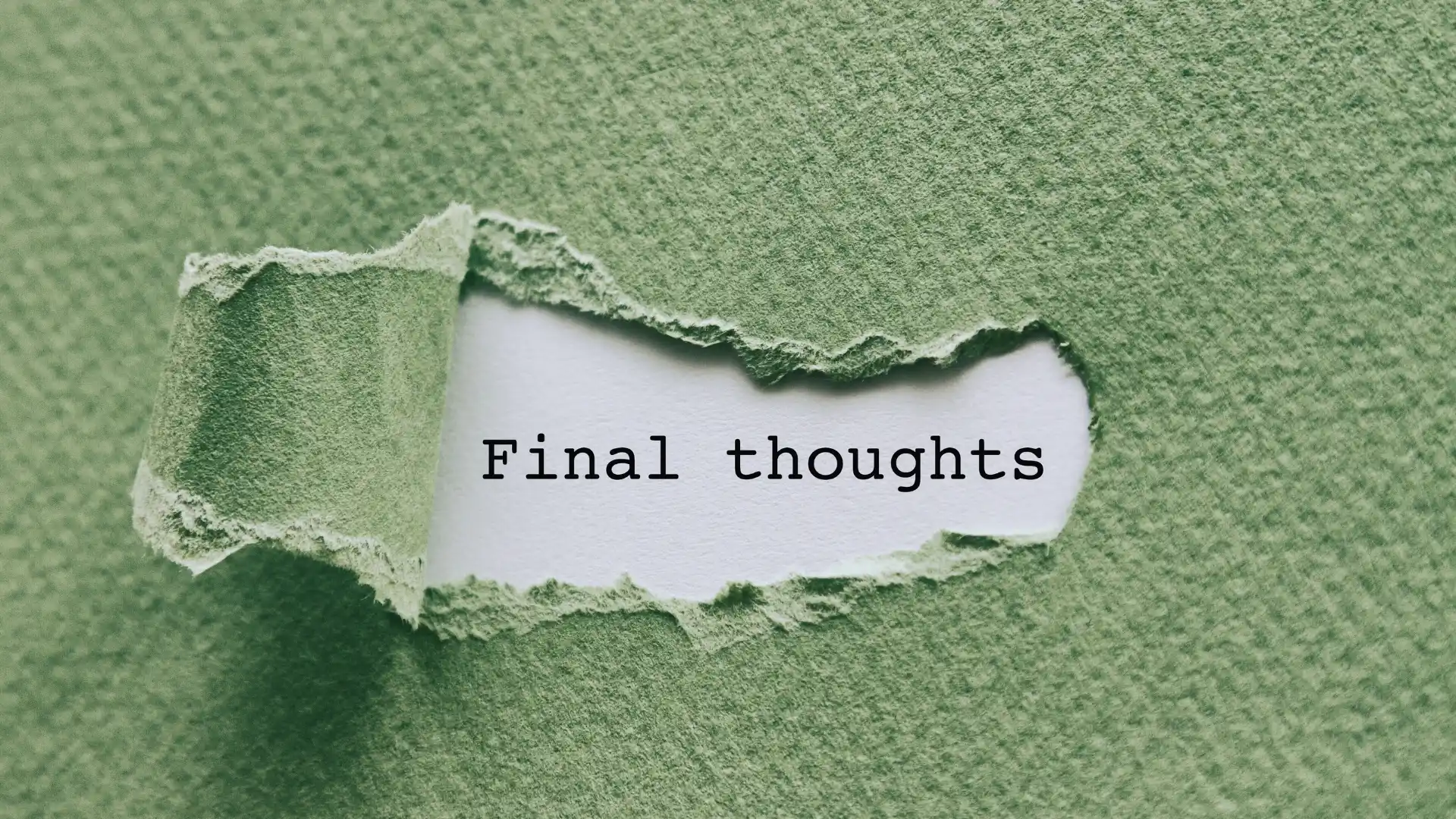 A piece of green textured paper is torn open, revealing the words "Goals for Change Management" typed in black on a white background underneath.