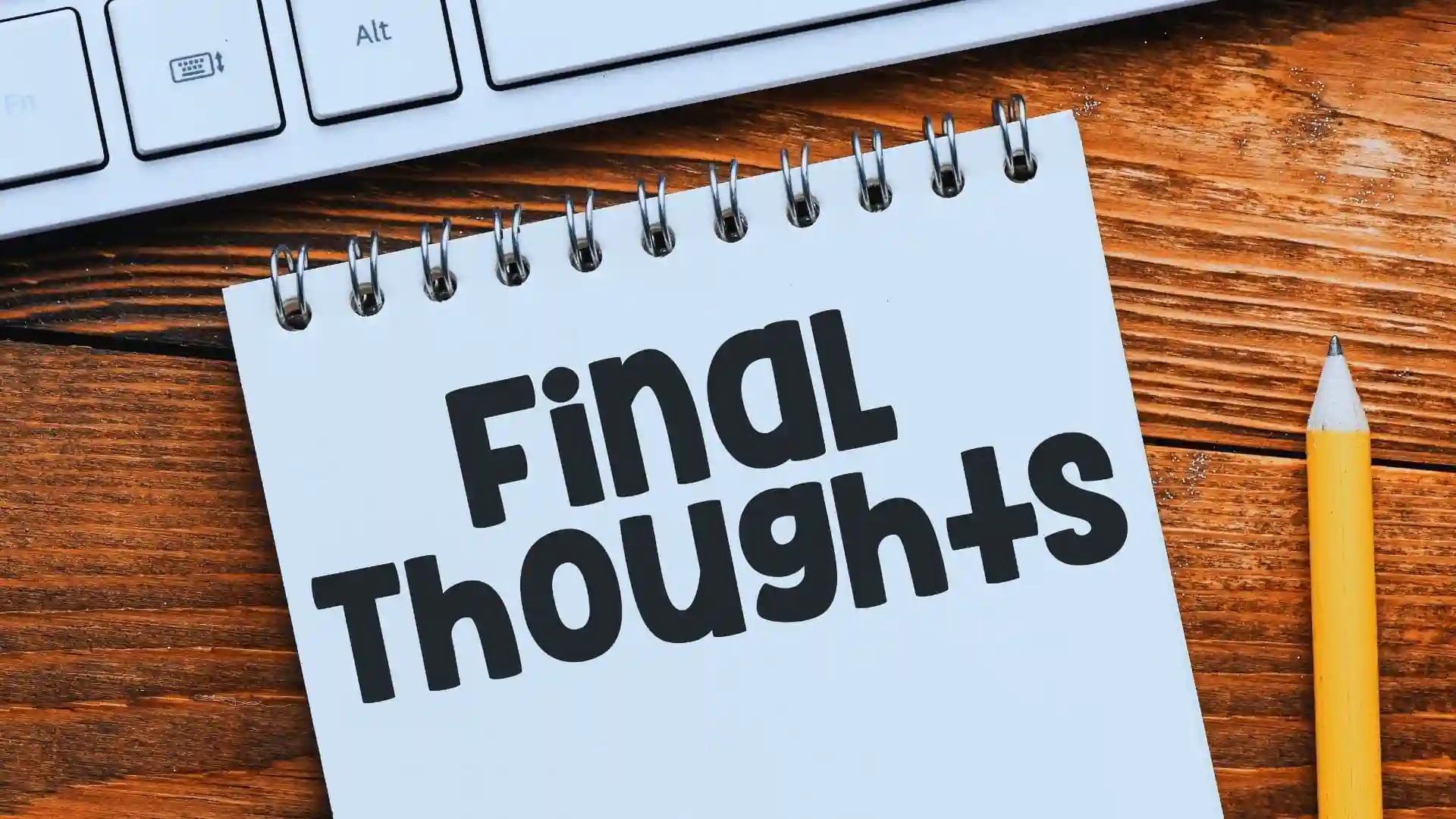 A notepad with the words "Final Thoughts" in bold black letters sits on a wooden desk next to a yellow pencil, part of a white keyboard, and hints of Agile Coaching inspiration for your reflections.