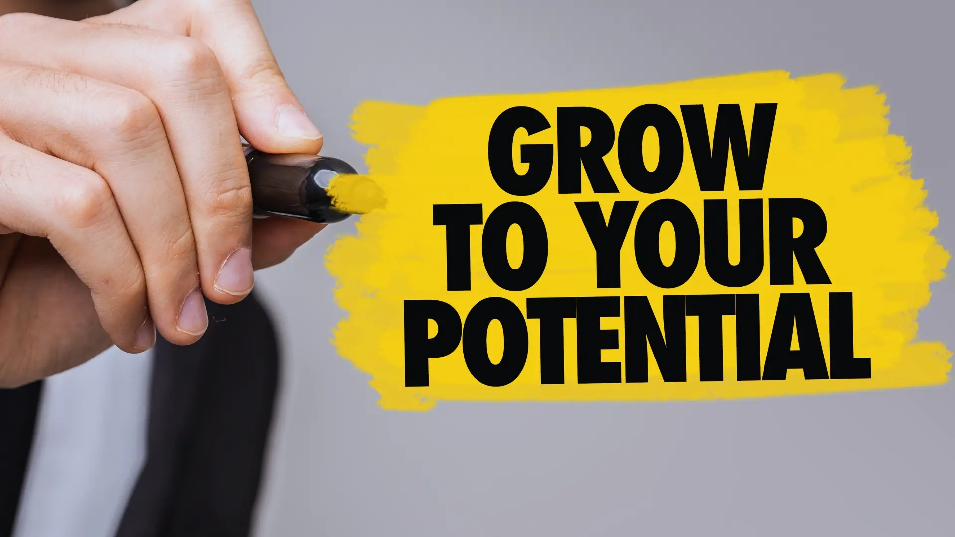 A hand holds a yellow highlighter, coloring a yellow brushstroke with bold black text that reads, "GROW TO YOUR POTENTIAL," against a gray background, symbolizing the functions of project management office in driving growth.