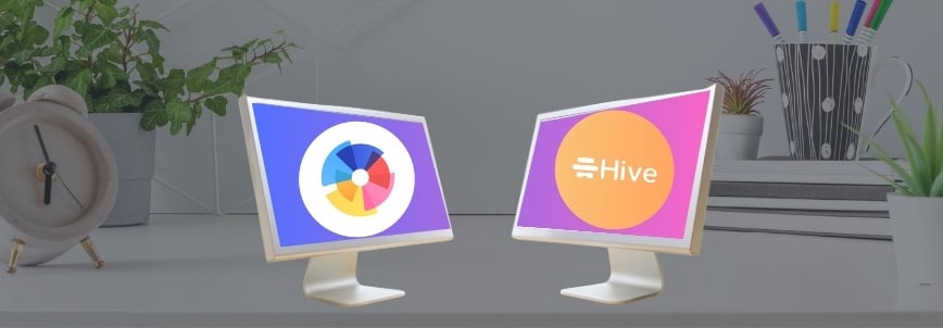 Two computer monitors on a desk display colorful logos, highlighting bvdash vs hive—one with a multicolored pie chart design and the other featuring "Hive" in a yellow circle. A clock, plant, and pen holder complete the background scene.