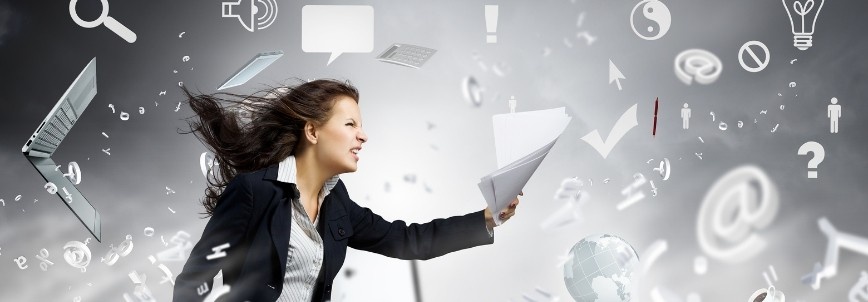 A woman in business attire stands amid swirling papers and digital icons, including email, search, and Project Progress Tracking in BVDash symbols, conveying a sense of chaos and information overload. Her hair and papers are blown by the wind.