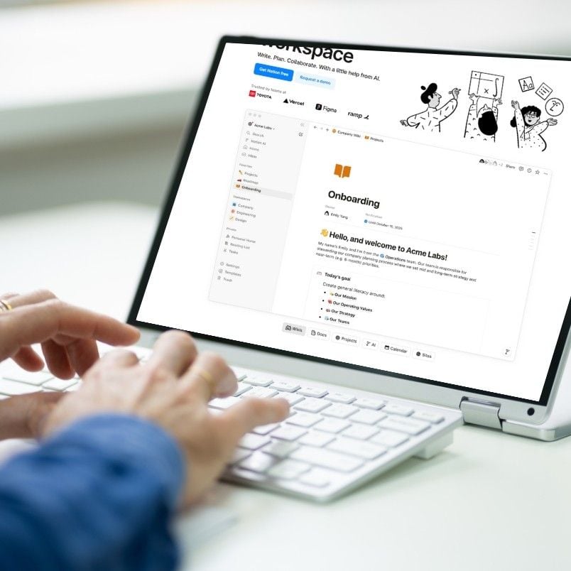Person typing on a white keyboard in front of a laptop displaying an onboarding document with Markdown in Notion, using a workspace app with folders and colorful illustrations on the screen.