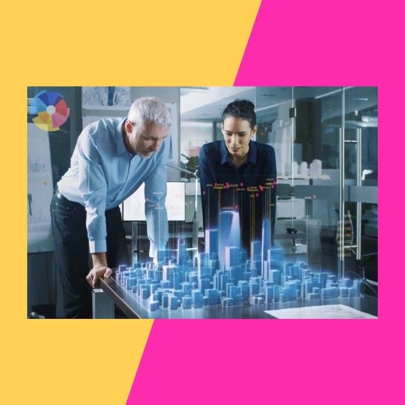 Two people lean over a table displaying a 3D holographic city model in an office, discussing the digital display powered by BVDash for Stakeholder Communication. The background features a vibrant pink and yellow split design.