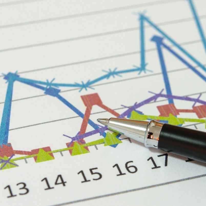 A close-up of a graph with colorful lines and data points, a black and silver pen resting on the chart—ideal for illustrating Root Cause Analysis—with numbers along the x-axis.