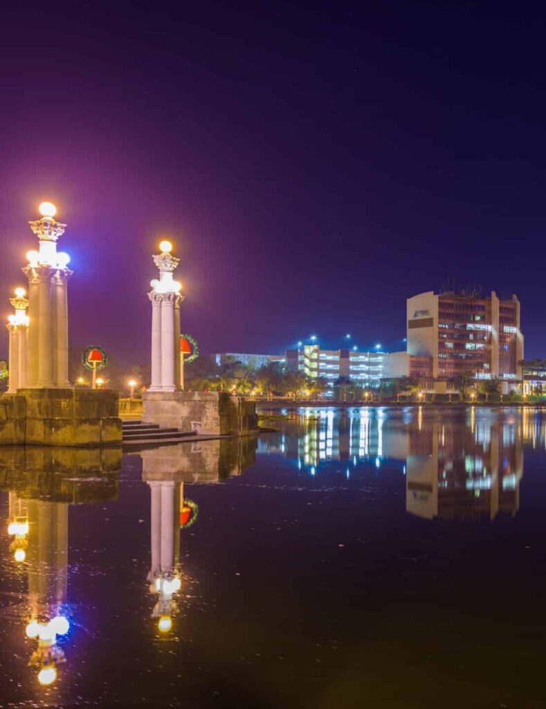 Illuminated Lakeland townscape reflected on the lake at dawn; start PMP® or CAPM® training with free 7-day access, live office hours, and 1-on-1 coaching.